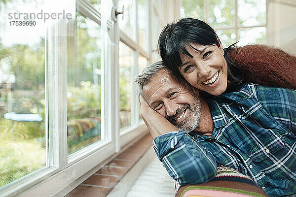 Happy woman leaning on man at home