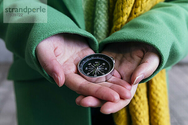 Hands of woman holding navigational compass