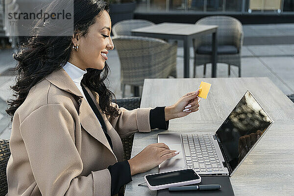 Geschäftsfrau mit Kreditkarte beim Online-Shopping über Laptop