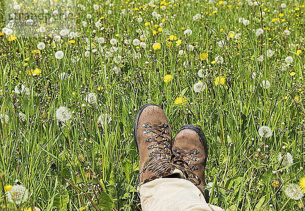 Man with hiking boots relaxing at meadow