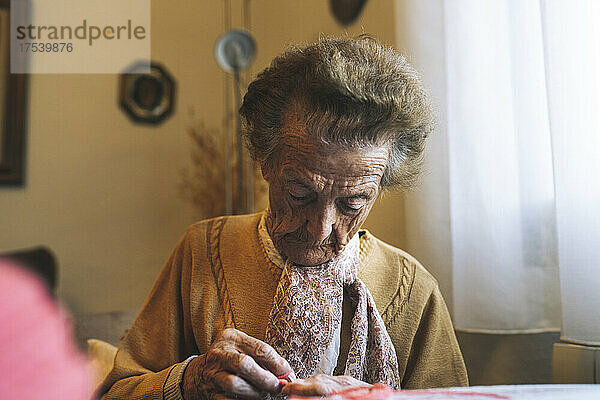 Ältere Frau im Ruhestand strickt zu Hause