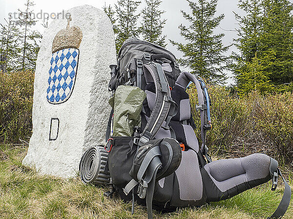 Backpack left beside stone border post in Bavarian Forest