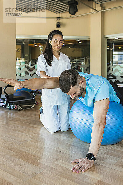 Athlete exercising on sports ball in gym