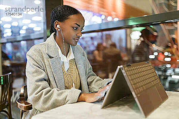 Girl using touch screen laptop at cafe