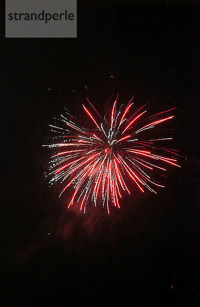 Rotes Feuerwerk explodiert vor klarem Nachthimmel