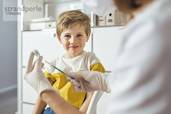 Lächelnder Junge mit Arzt im Impfzentrum