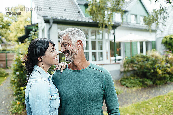 Smiling mature couple looking at each other in backyard