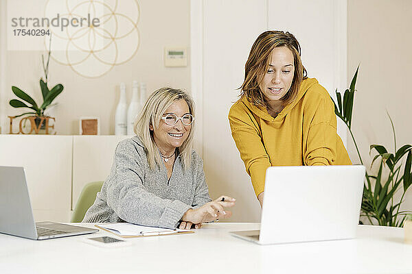 Geschäftsfrauen diskutieren über Laptop in Bürobesprechung