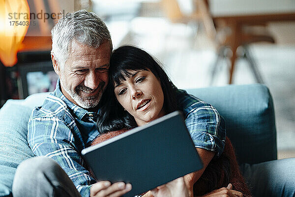 Mature couple using tablet PC at home