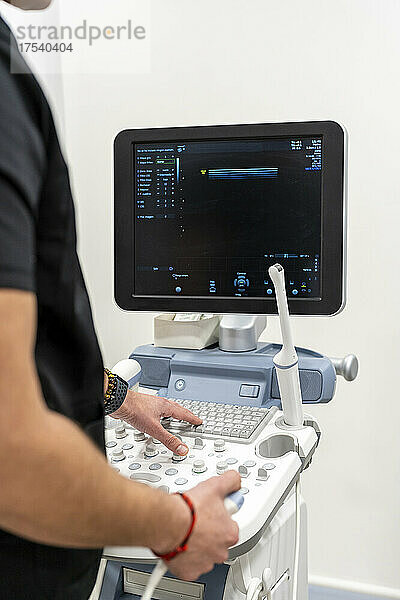 Arzt benutzt Tastatur an medizinischen Geräten im Krankenhaus