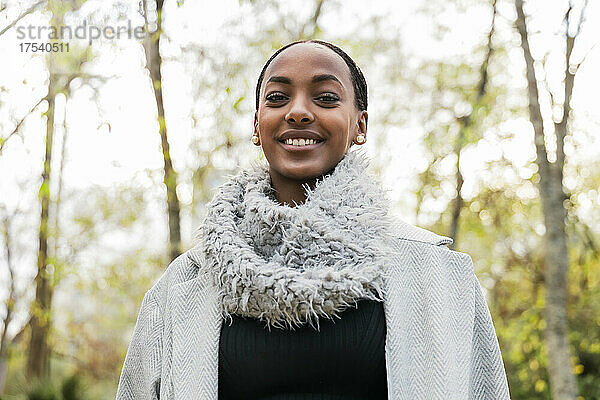 Smiling girl wearing scarf and trench coat