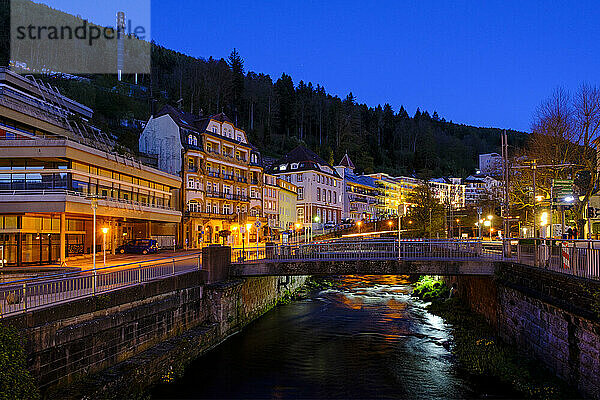 Germany  Baden-Wurttemberg  Bad Wildbad  Bathhouses along Enz river canal at dusk