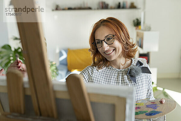 Lächelnde Frau  die zu Hause malt