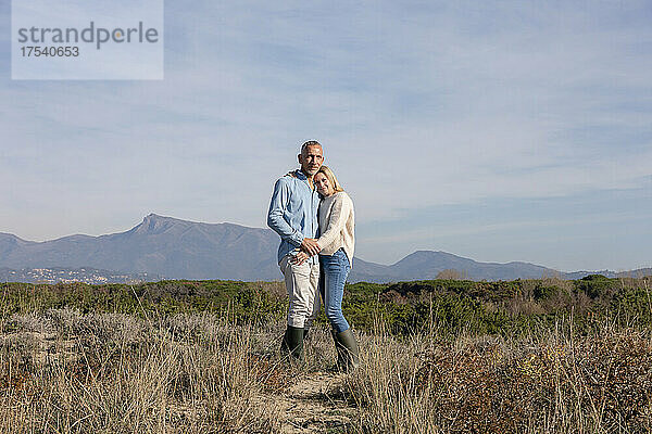 Romantic couple standing together at dunes