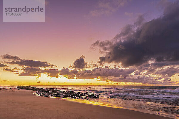 Sandy coastal beach at moody sunrise
