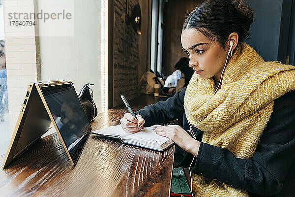 Konzentriertes E-Learning für Mädchen über Laptop im Café
