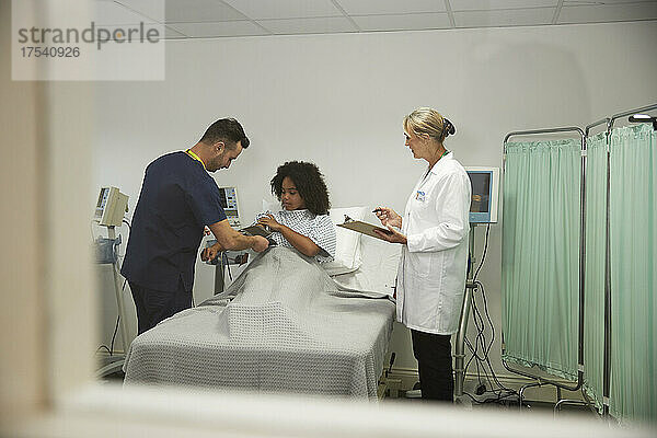 Gesundheitspersonal überprüft den Blutdruck eines Patienten im Krankenhaus