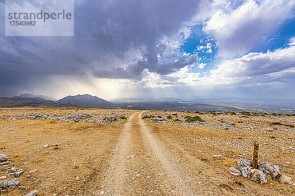 Cloudscape over empty dirt road in Andalucia  Spain  Europe
