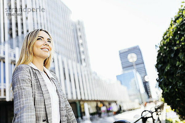 Smiling businesswoman contemplating in city