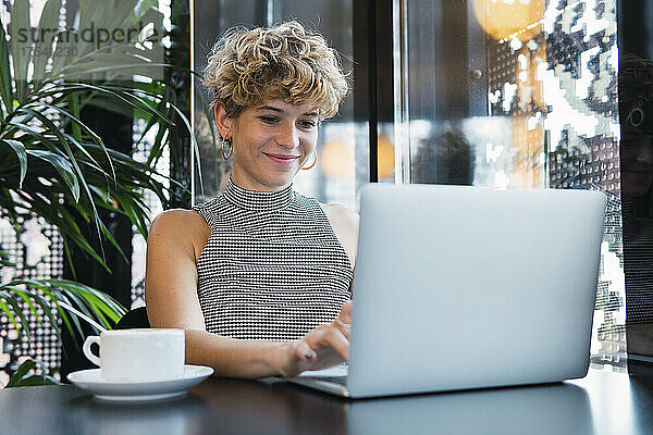 Junge Geschäftsfrau arbeitet am Laptop im Café