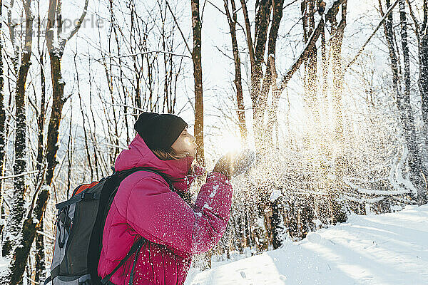 Tourist weht im Urlaub Schnee im Wald