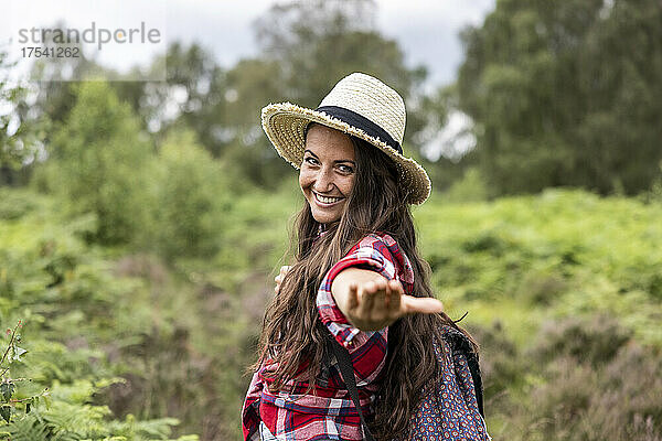 Smiling woman wearing hat gesturing at Cannock Chase