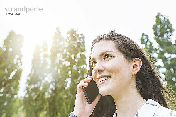 Smiling young woman talking on mobile phone