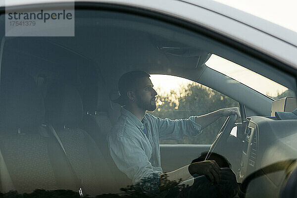 Delivery man driving van seen through window