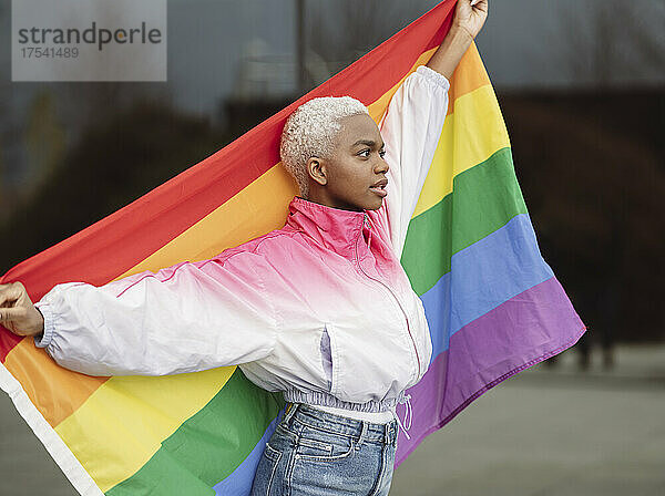 Confident LGBTQIA woman holding rainbow flag