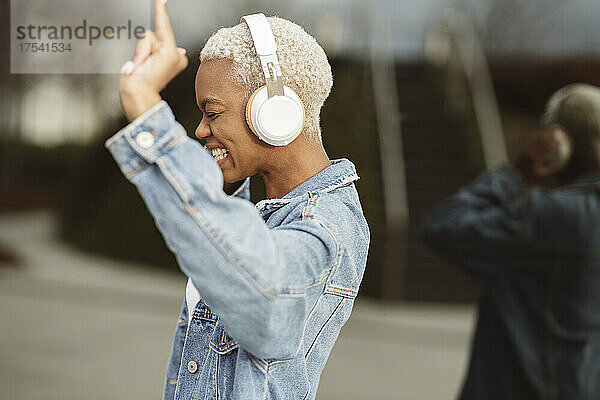 Cheerful woman enjoying music on wireless headphones