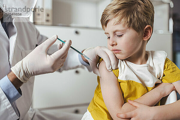 Junge wird im Zentrum vom Arzt geimpft