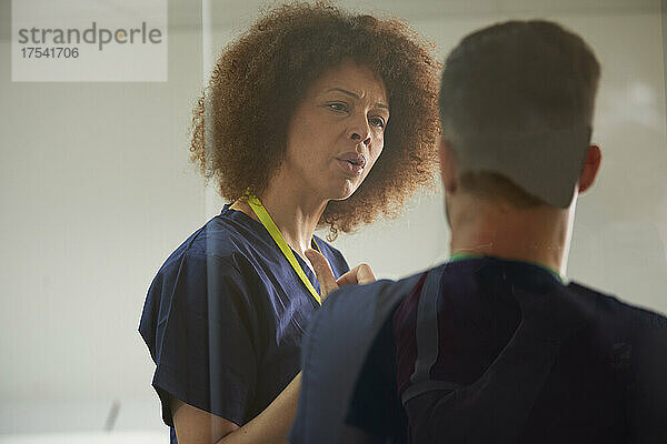 Female nurse talking to colleague in medical room