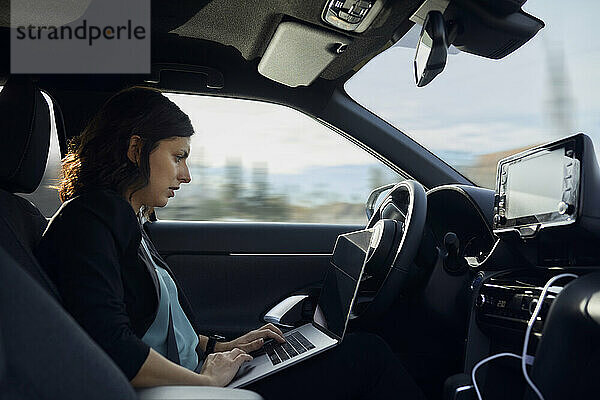 Geschäftsfrau benutzt Laptop im fahrerlosen Auto