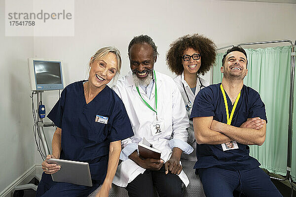 Fröhliche Ärzte und Krankenschwestern zusammen im Krankenzimmer