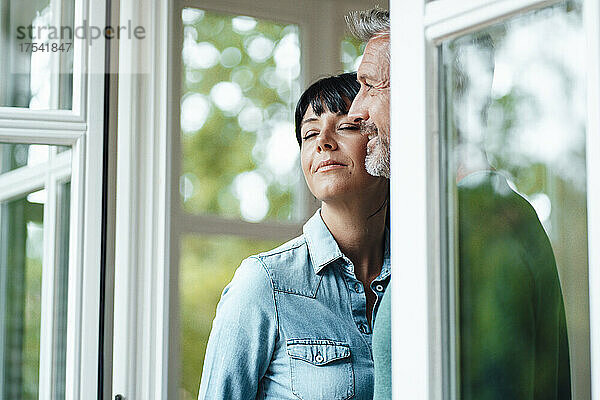 Nachdenklicher Mann mit Frau am Fenster