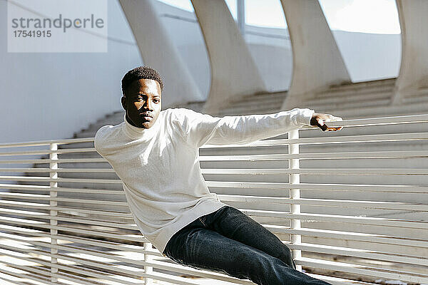 Carefree man leaning on white railing