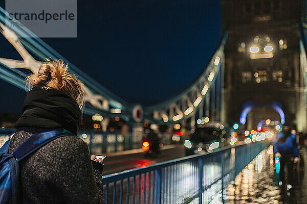 Frau benutzt Smartphone an der Tower Bridge  London  England  Großbritannien