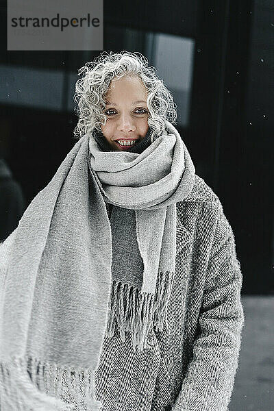 Smiling woman with gray hair wrapped in scarf