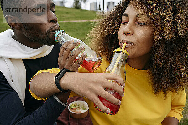 Freunde trinken Limonade im Park