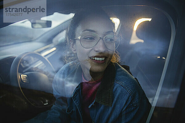 Smiling woman seen through car window