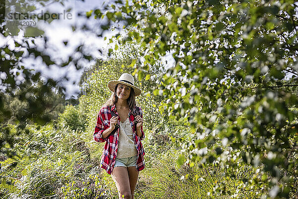 Frau steht an einem sonnigen Tag im Wald bei Cannock Chase