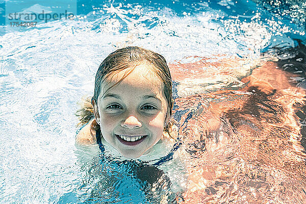Smiling girl enjoying in swimming pool
