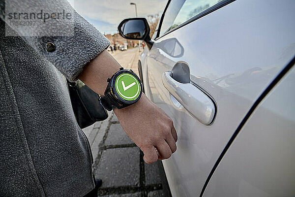 Woman unlocking car door with smart watch