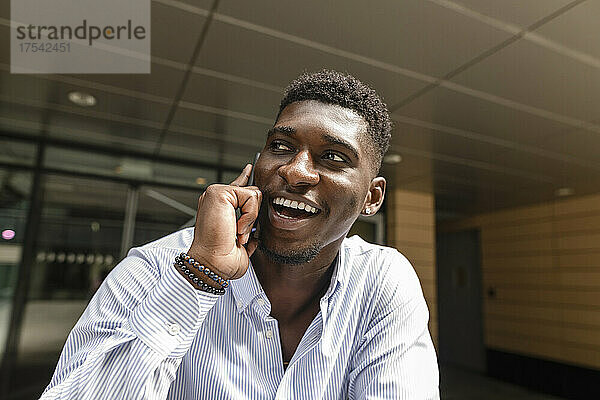 Young man laughing and talking on smart phone