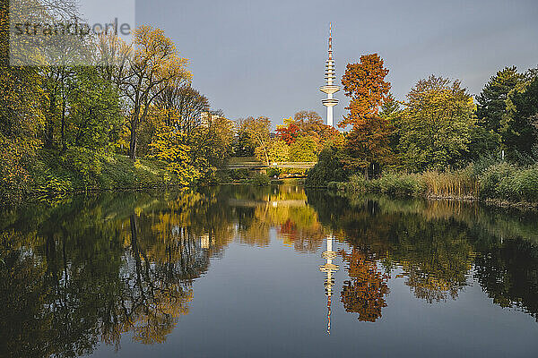 Deutschland  Hamburg  Herbstbäume spiegeln sich auf der Oberfläche eines glänzenden Sees im Wallanlagenpark