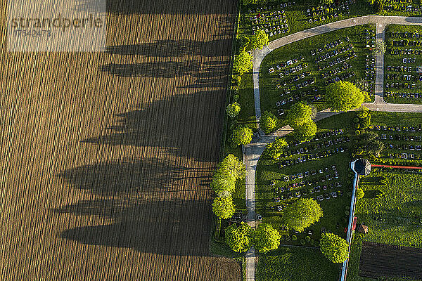 Germany  Bavaria  Berg  Aerial view of plowed field next to countryside cemetery