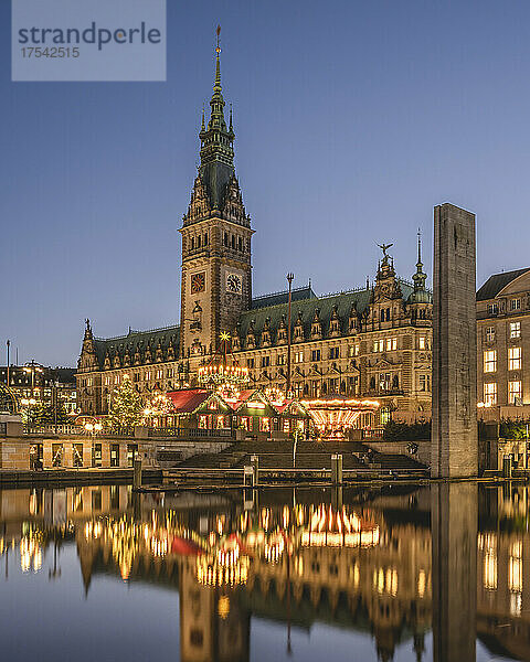 Deutschland  Hamburg  Weihnachtsmarkt vor dem Hamburger Rathaus  das sich in der Abenddämmerung in der Binnenalster spiegelt