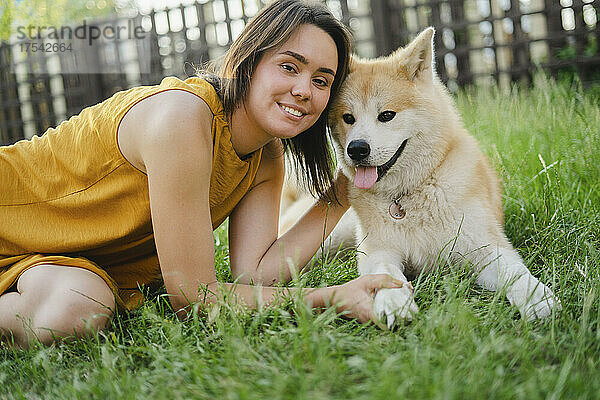 Smiling woman with Akita dog on grass