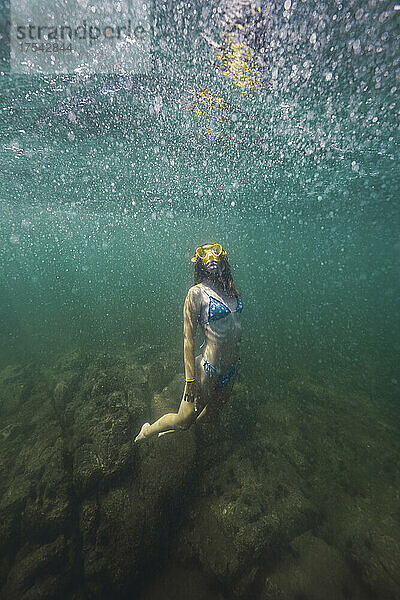Young woman in bikini swimming undersea