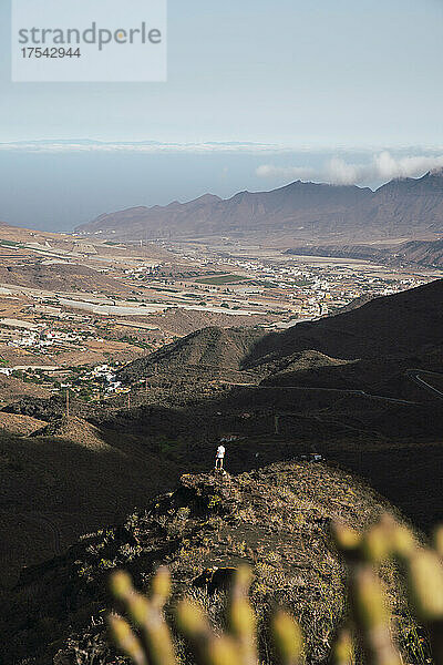 Junger Mann steht auf einem Berg in Los Azulejos De Veneguera  Gran Canaria  Kanarische Inseln  Spanien